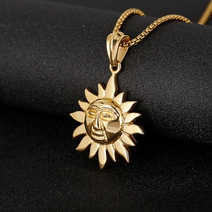 Detailed view of a golden sun face pendant necklace with polished finish on black background
