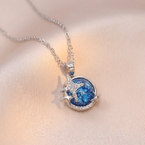 Starry blue planet necklace in silver finish with pavé zircon stars on silk background