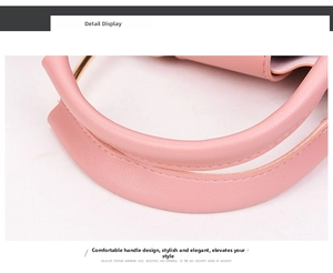 Detail of pink handbag featuring a round handle with fine stitching and golden hardware