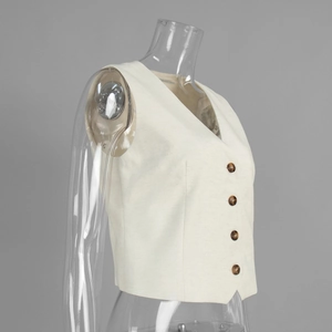 Detailed macro view of the ivory cotton-linen vest fabric and brown amber-textured buttons