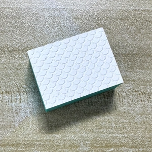 Macro detail of the dual-layer cleaning sponge with white scale texture and green layer