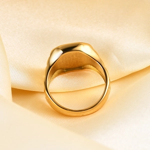 Close-up of golden stainless steel square shell ring on soft silk fabric background