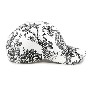 White baseball cap with black vintage floral print and curved brim in classic French style