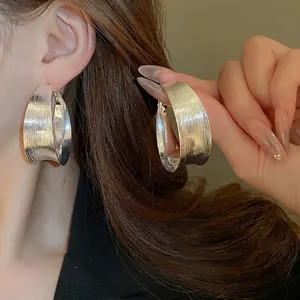 Elegant silver textured hoop earrings with a minimalist wrinkled brushed metal design