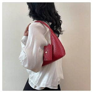 Detail of red woven shoulder bag in triangle shape with matching chain coin purse
