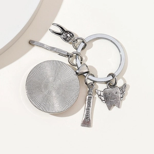 Detail of vintage silver dental keychain with tooth, toothpaste and toothbrush charms