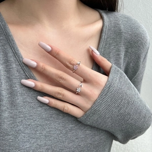 Close-up of S925 sterling silver leaf rings with pink and white zircon stones on a model hand