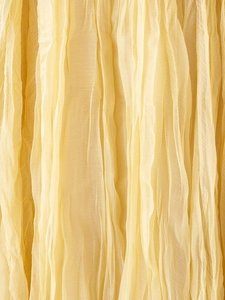 Detail of yellow pleated fabric texture showing fine vertical creases and soft chiffon material
