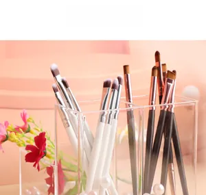 Detail of eyeshadow brushes with rose gold ferrules in a clear acrylic storage case