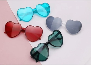 Top view of colorful heart-shaped sunglasses in red, blue, grey, and green lenses