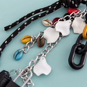 Macro shot of colorful shell charms and metal chain links for DIY handbag accessories