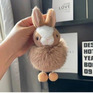 Close-up of a soft plush bunny keychain with fluffy brown and white faux fur texture