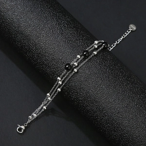Detail of multi-layer stainless steel beaded bracelet with lobster clasp on display