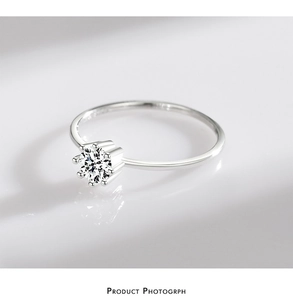 Detail of classic six-prong setting with a brilliant round-cut diamond on silver band