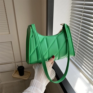 Vibrant green quilted leather baguette shoulder bag featuring a stylish crescent design