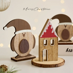 Wooden Christmas table decor with penguin and snow-capped house on rustic timber base