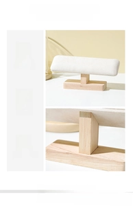 Detailed view of T-bar jewelry stand with natural wood base and soft white velvet roll