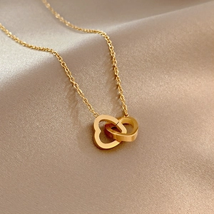 18k gold interlocking double heart pendant necklace on smooth champagne silk background