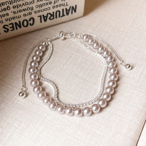 Close-up of double-layer bracelet with purple pearls, zircon chain, and adjustable clasp