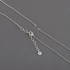 Detail of silver bead chain with lobster clasp, extender, and faceted crystal pendant
