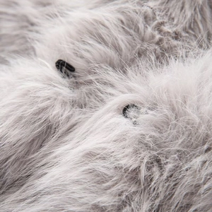 Detail of grey faux fur texture with black metal hook and eye fasteners on a vest