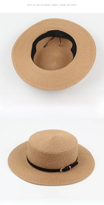 Detail view of a flat top straw hat with black leather strap and gold buckle adjustment