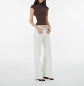 Detail view of a slim fit brown mock neck t-shirt paired with white wide-leg trousers
