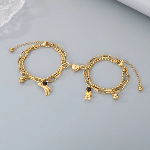 Detail of gold astronaut bracelets with heart magnetic clasp and layered chain design