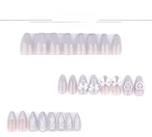 Détail d'ongles amande cat-eye avec nœuds 3D, perles et breloques en cœur