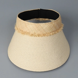 Detailed close-up of woven straw sun hat with fringe edges and black elastic inner band