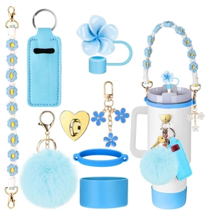Close-up of blue crochet daisy strap and plush ball accessories set for tumblers