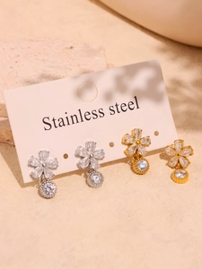 Détail de boucles d'oreilles fleur en acier inoxydable doré et argenté avec zircons
