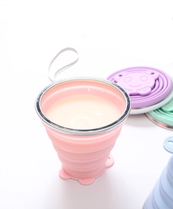 Close-up of pink collapsible food-grade silicone travel cup with metal rim and lanyard hole
