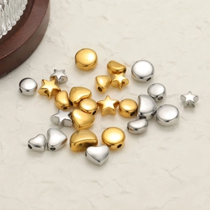 Golden and silver geometric metal pendants including heart star and moon shapes
