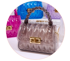 Detail of leaf pattern jelly bag with gold twist lock, rivets, and chain strap