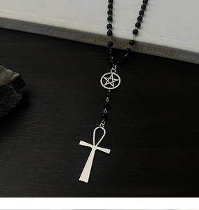 Détail macro du collier gothique à perles noires avec pendentifs Ankh et Pentagramme