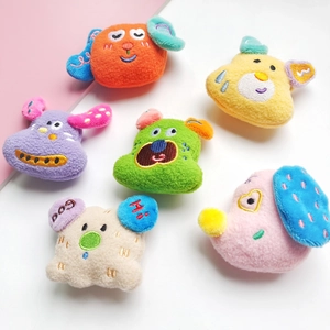 Close-up of colorful plush dog doll charms with custom embroidery and cute cartoon faces