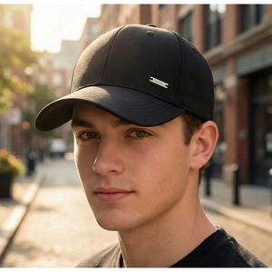 Detailed close-up of a black baseball cap featuring twill texture and a silver metal logo