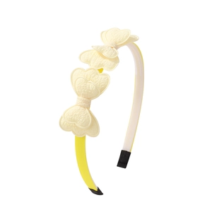 Detail of yellow headband featuring multi-layer cream heart bow with relief fabric texture