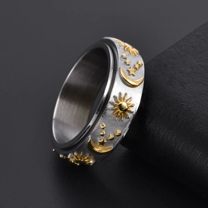 Rotatable stainless steel ring with gold sun, moon, and star relief on brushed silver band