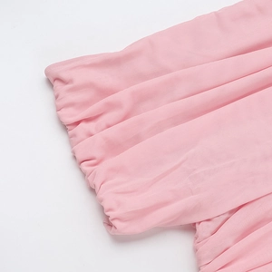 Detailed close-up of pink mesh fabric featuring elegant ruched pleats on the dress