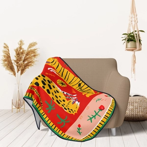 Detail of red flannel blanket with artistic big cat pattern draped over an armchair