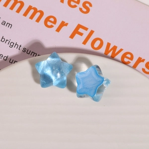 Macro view of blue translucent resin star charms with a marble texture for jewelry DIY