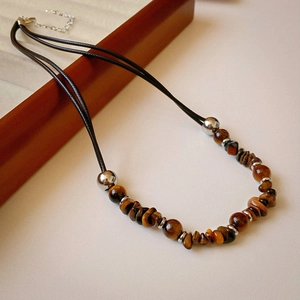 Detail of tiger eye stone necklace with black wax rope and silver metallic beads