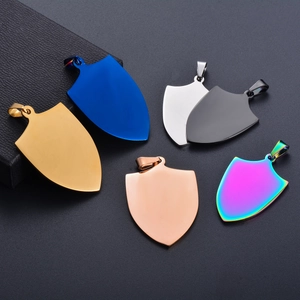 Pendentifs boucliers en acier titane polis en six couleurs sur une boîte à bijoux noire