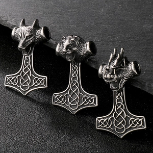 Détail de trois marteaux de Thor vikings avec têtes de loup, lion et dragon sur pierre