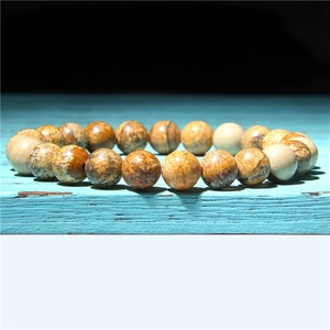 Macro shot of natural sunstone beads with earthy textures on a vintage blue surface