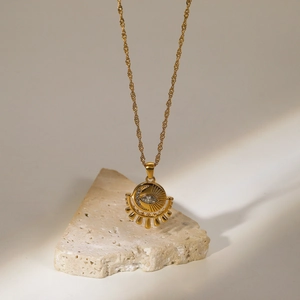 Détail du pendentif œil en or 18 carats avec zircone sur socle en pierre texturée