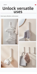 Detail view of white wall-mounted folding hooks holding hangers, mugs, and bags on a wall