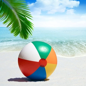 Colorful inflatable rainbow beach ball with water droplets on a sunny seaside background